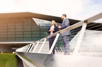 Two investors standing on skybridge